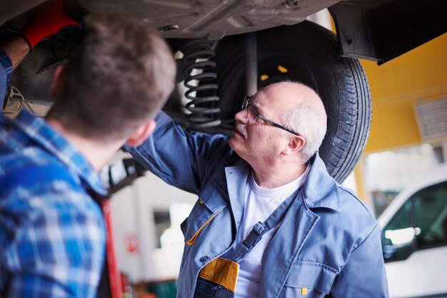 Mecánicos reparando un coche en el taller.