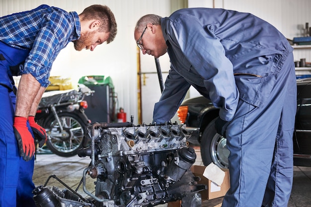 Mecánicos reparando un coche en el taller.