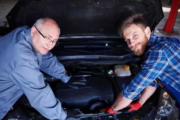 Mecánicos reparando un coche en el taller.