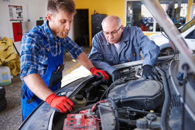 Mecánicos reparando un coche en el taller.