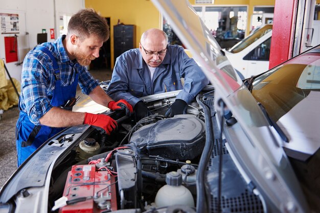 Mecánicos reparando un coche en el taller.