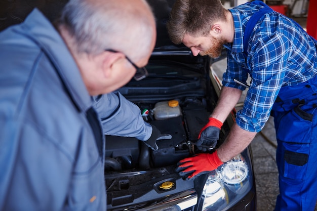 Mecánicos reparando un coche en el taller.