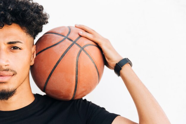 Media cara de hombre negro con baloncesto.