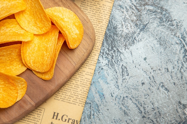 Media foto de deliciosas papas fritas caseras en la tabla de cortar de madera en el periódico