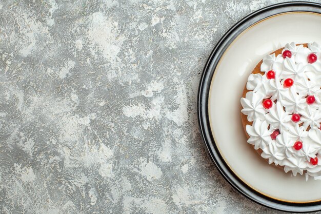 Media foto de delicioso pastel cremoso decorado con frutas en el lado izquierdo sobre fondo de hielo