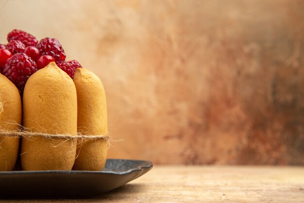 Media foto de un pastel de regalo con frutas en el lado derecho de la tabla de colores mezclados.