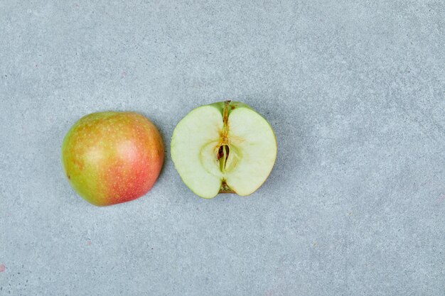 Media manzana fresca cortada en gris.