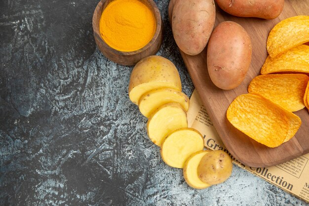 Media toma de deliciosas papas fritas caseras en tabla de cortar de madera en material de periódico