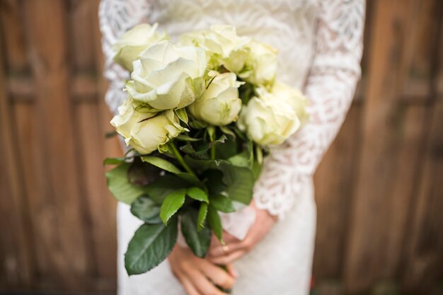 Mediados de sección de la novia con ramo de rosas hermosas
