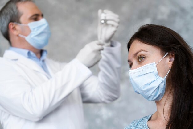 Medic preparando la vacuna para el paciente femenino