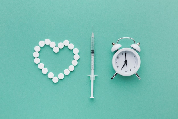 Foto gratuita medicamentos blancos médicos y reloj blanco con jeringa