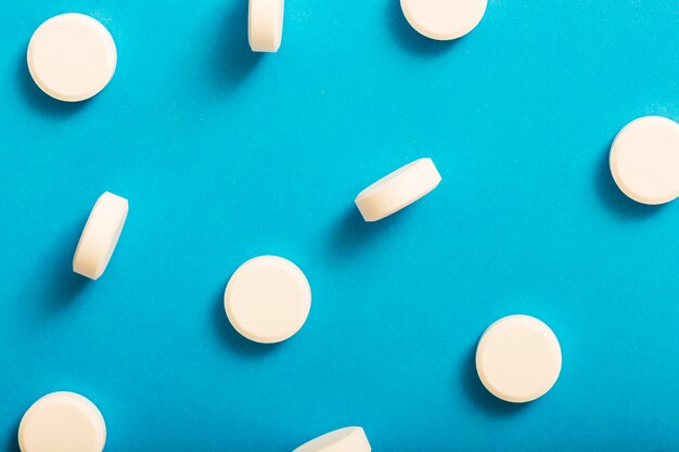 Medicina blanca redonda de la tableta en fondo azul