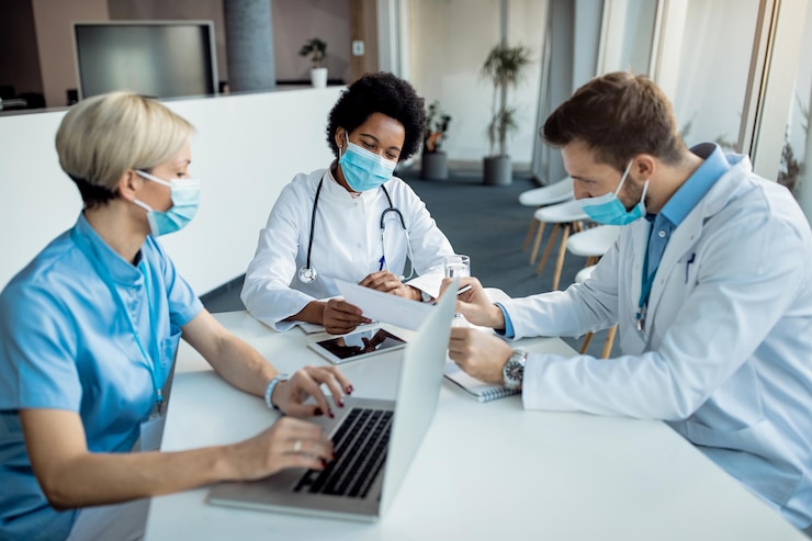 Foto gratuito médico afroamericano analizando informes médicos con sus colegas en la clínica