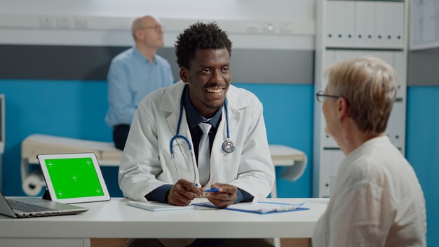 Médico afroamericano discutiendo con mujer mayor