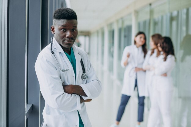 Médico afroamericano hombre de pie en el pasillo del hospital