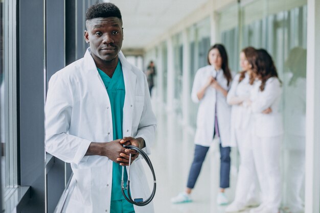 Médico afroamericano hombre de pie en el pasillo del hospital