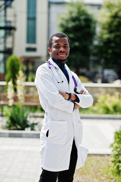Médico afroamericano masculino en bata de laboratorio con estetoscopio al aire libre