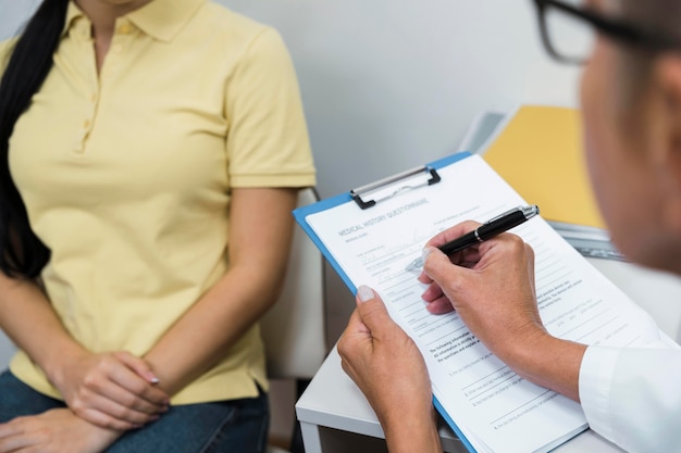 Médico de alto ángulo consultar a un paciente en su oficina