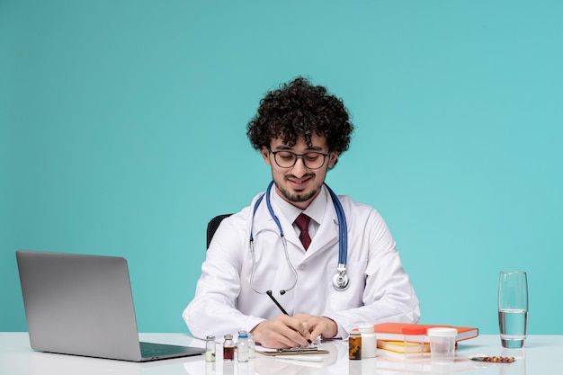 Médico en bata de laboratorio joven serio guapo doctor trabajando en computadora escribiendo prescripción