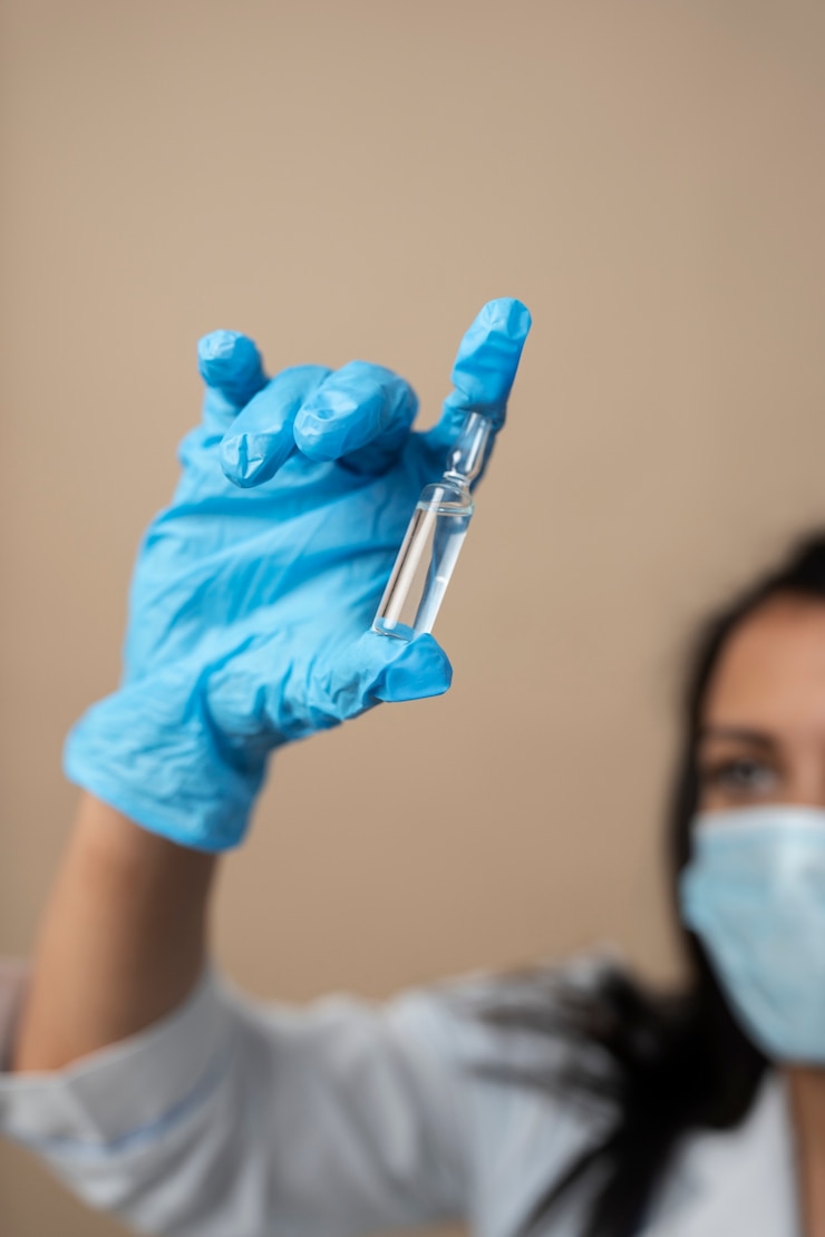 Foto gratuito médico borroso con guante sosteniendo vial