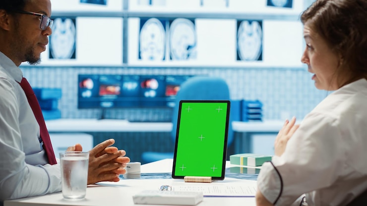 Foto gratuito el médico de cabecera señala el modelo de pantalla verde en el dispositivo