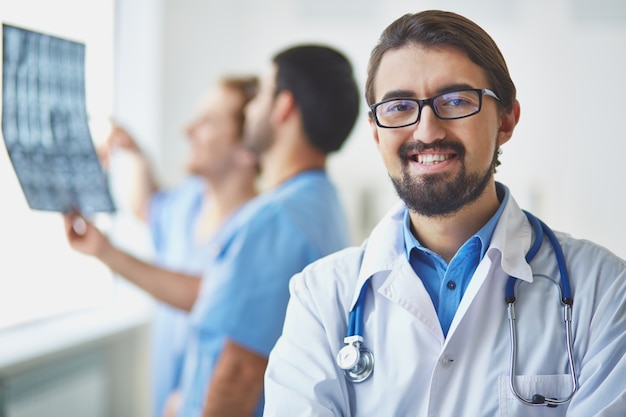 Foto gratuita médico con compañeros trabajando de fondo