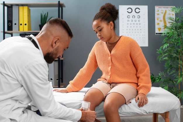 El médico cuidando a un niño afroamericano.