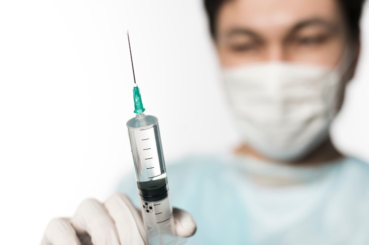 Foto gratuito médico desenfocado con jeringa