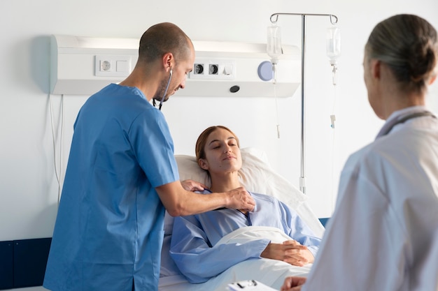 Médico y enfermera ayudando al paciente a cerrar