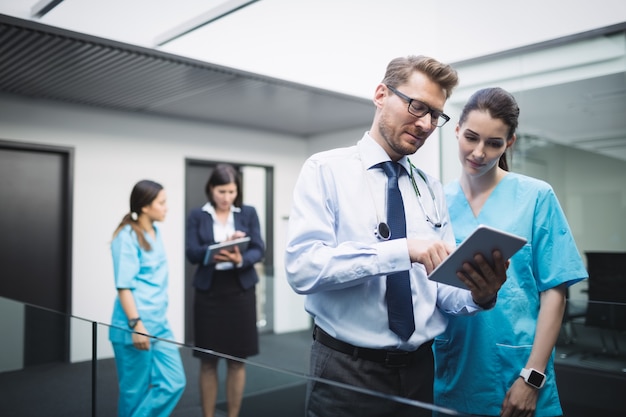 Médico y enfermera discutiendo sobre tableta digital