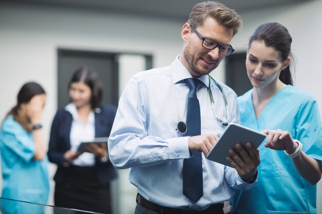 Médico y enfermera discutiendo sobre tableta digital