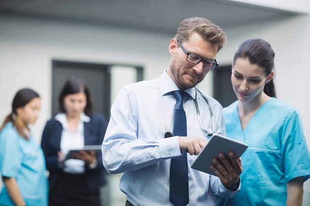 Médico y enfermera discutiendo sobre tableta digital