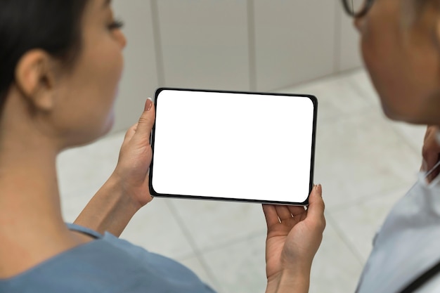 Médico y enfermera mirando una tableta en blanco