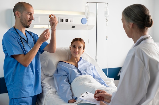 Médico y enfermera de tiro medio ayudando al paciente