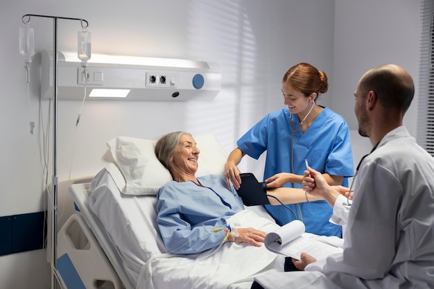 Foto gratuita médico y enfermera de tiro medio revisando al paciente