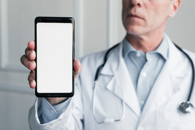 Foto gratuita médico enseñando un teléfono móvil