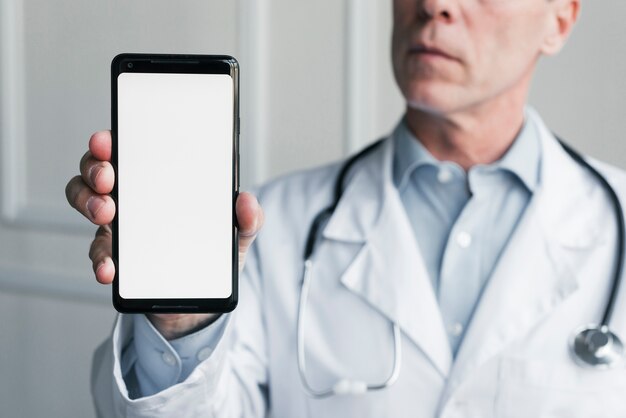 Médico enseñando un teléfono móvil