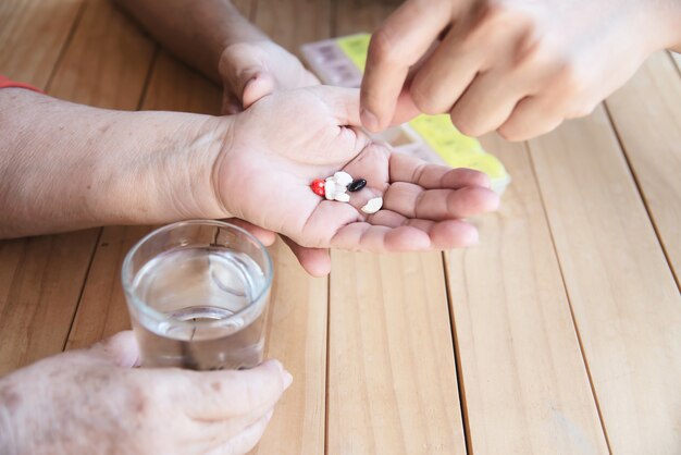 El médico es ayudar al paciente a comer la tableta de medicina en el pastillero correctamente