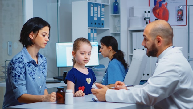 Médico escribiendo diagnóstico y tratamiento en el portapapeles. Médico, médico especialista en medicina que brinda servicios de atención médica, consulta, examen en el gabinete del hospital