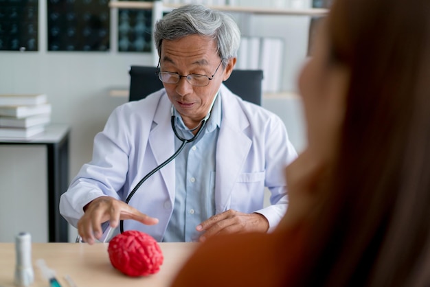 Foto gratuita médico experto asiático examina y explica a una paciente asiática con el concepto de ideas de salud de cuidado y felicidad