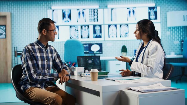 Médico indio y paciente estrechando la mano en una consulta médica