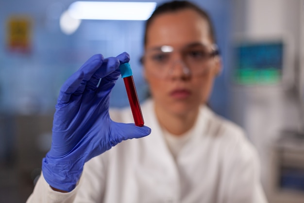 Médico de investigación científica con tubo de ensayo con sangre