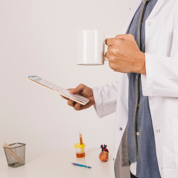 Foto gratuita médico con ipad y taza de café