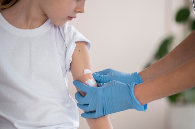 Médico joven asegurándose de que una niña esté bien después de la vacunación