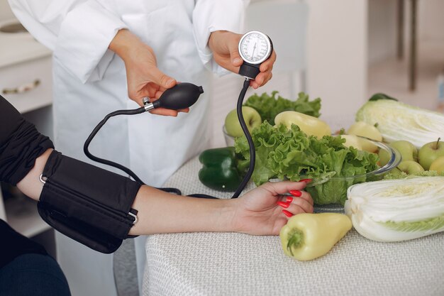 Médico mide la presión del paciente en la cocina.