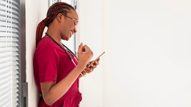 Médico mujer sonriendo a su teléfono