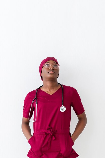 Médico de mujer en uniforme rojo mirando hacia arriba