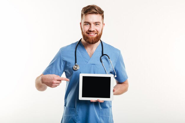 Médico o enfermera señalando con el dedo a la tableta de la pantalla en blanco