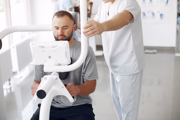 Foto gratuita médico con un paciente en la clínica de fisioterapia