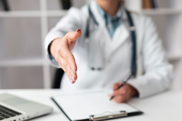 Médico de primer plano esperando para estrechar la mano de los pacientes